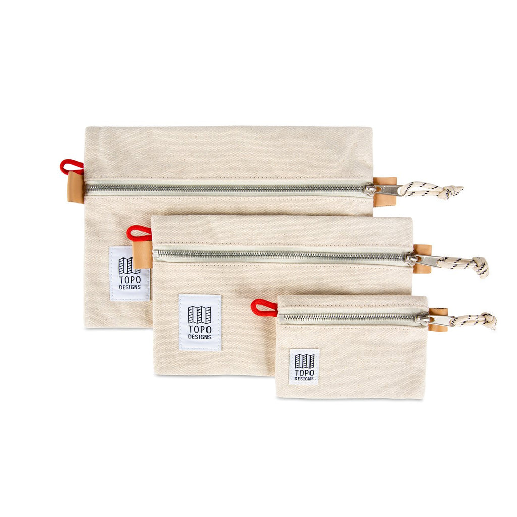 Topo Designs Accessory Bags in Natural Canvas. Three different sizes stacked on top of each other on a white background. 